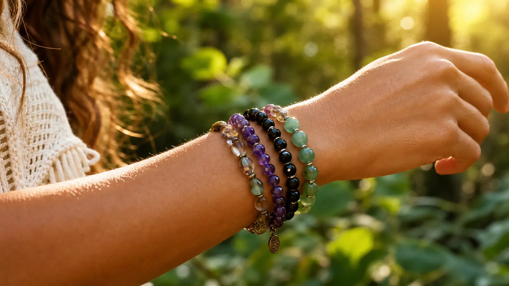 Close-up of a person's wrist wearing multiple beaded bracelets with a natural background