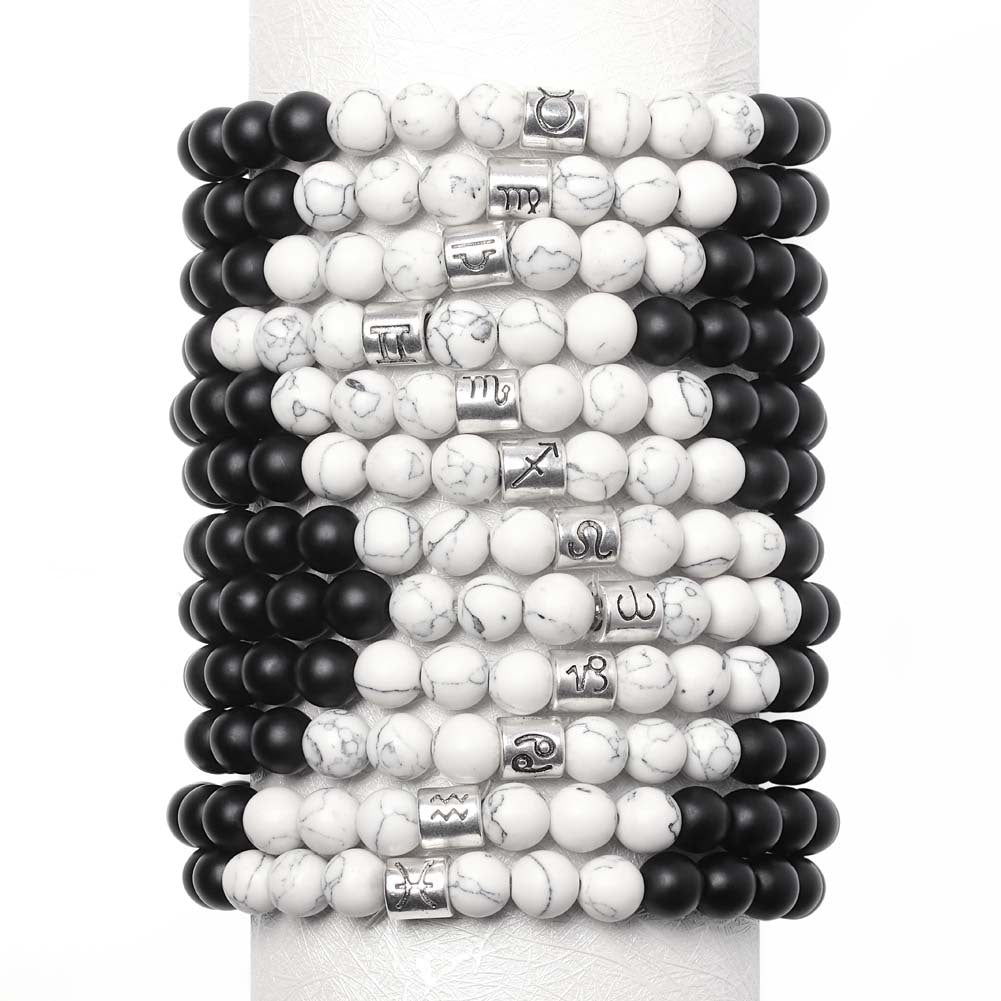 Stack of black and white beaded bracelets on a white background