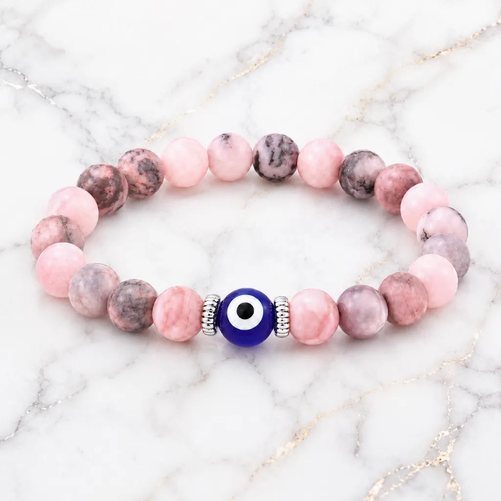 Agate evil eye crystal bracelet displayed on marble, elegant spiritual jewelry for positive healing energy