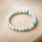 Amanzonite bracelet stretch bead bracelet on wooden surface with aqua stones, calming gemstone accessory modern look