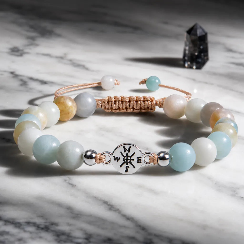 Amazonite gemstone bracelet with polished beads and silver charm styled on luxury marble surface.
