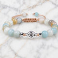 Amazonite beaded bracelet with calming aqua gemstones and silver charm displayed on marble backdrop.