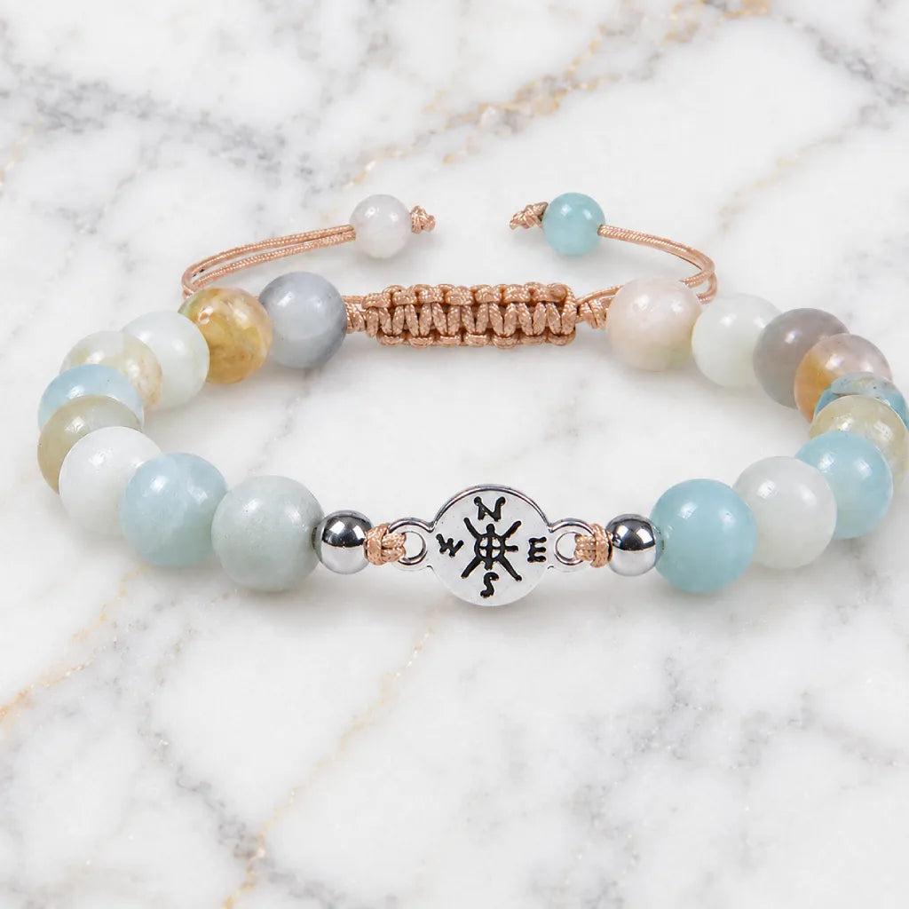 Amazonite beaded bracelet with calming aqua gemstones and silver charm displayed on marble backdrop.