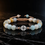 Amazonite healing bracelet with polished crystal beads and reflective marble backdrop for calming energy.