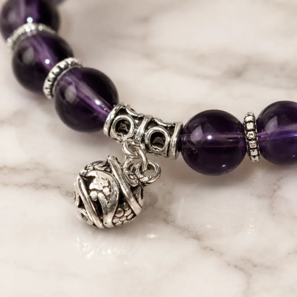 Violet Serenity amethyst bracelet on a soft gray velvet box with faceted purple beads, showing genuine natural gemstone color, polished detail, and a gift-ready display for giving.