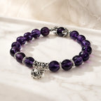Violet Serenity amethyst bracelet with faceted purple gemstone beads displayed on white, showing genuine natural amethyst color, polished texture, and clean stretch design in view.