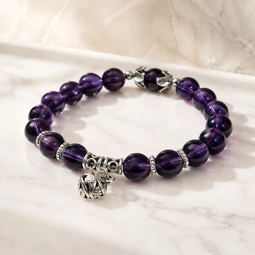 Violet Serenity amethyst bracelet with faceted purple gemstone beads displayed on white, showing genuine natural amethyst color, polished texture, and clean stretch design in view.