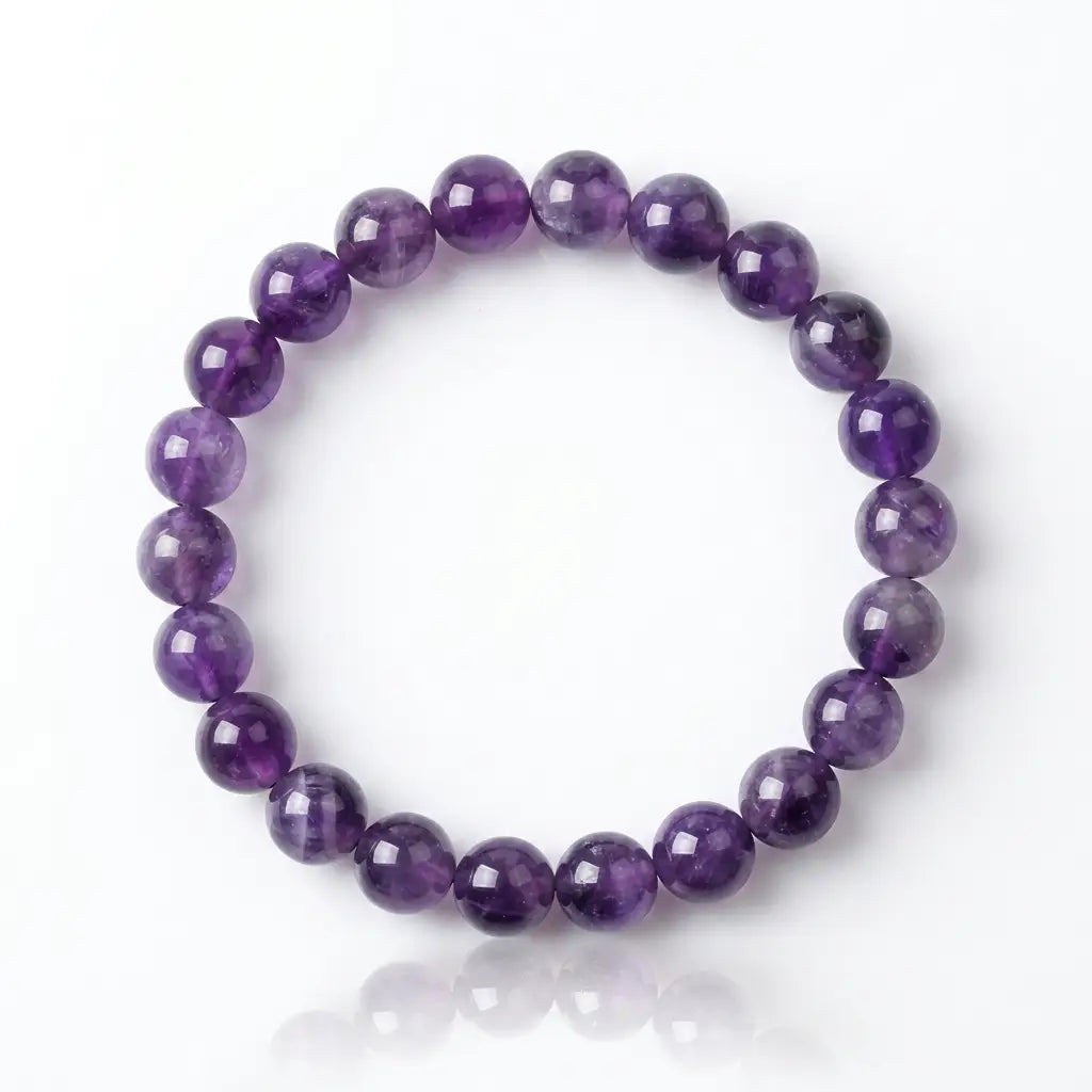 Amethyst bracelet with polished purple round beads on white background, calming gemstone jewelry for thoughtful gifting