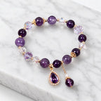Amethyst crystal bracelet on marble surface with polished gemstone beads for timeless beauty appeal