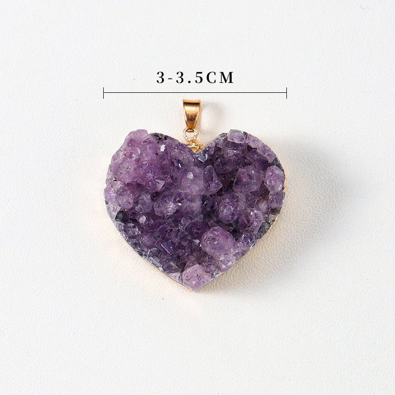 Amethyst heart pendant close-up with purple crystal points, heart shape, gold-color edging, small bail, and a measured width of approximately 3 to 3.5 centimeters, on white studio.