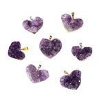 Amethyst heart pendant assortment showing varied purple crystal clusters, heart shapes, gold- and silver-color edging, and little bails against a clean white background in a group.