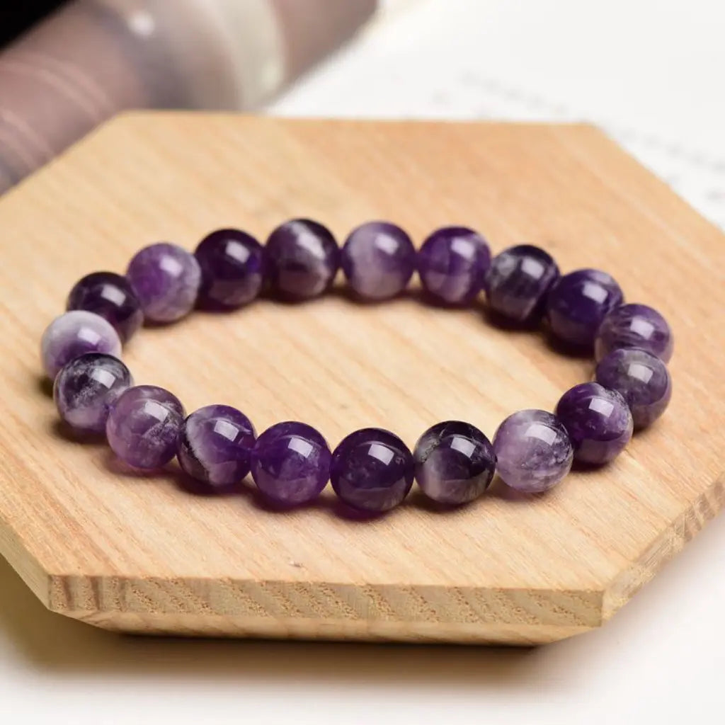 Amethyst jewelry polished gemstone bead bracelet on wooden display featuring natural crystal elegance and calming energy