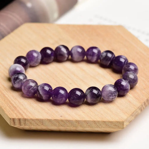 Amethyst jewelry polished gemstone bead bracelet on wooden display featuring natural crystal elegance and calming energy