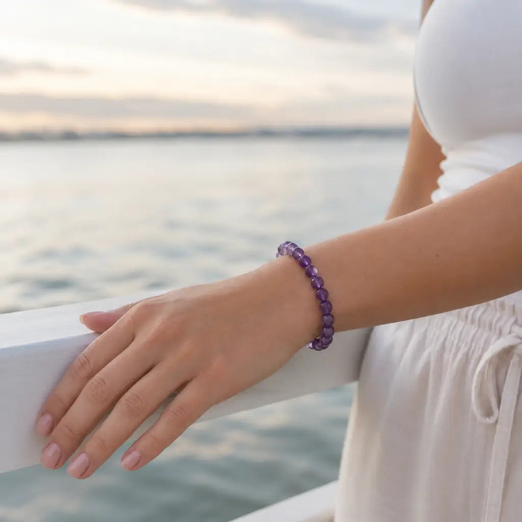 Amethyst jewelry worn near ocean scenery with faceted crystal bracelet for peaceful lifestyle elegance