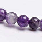Amethyst jewelry macro crystal bead detail showing polished purple gemstones with luxurious handcrafted bracelet texture