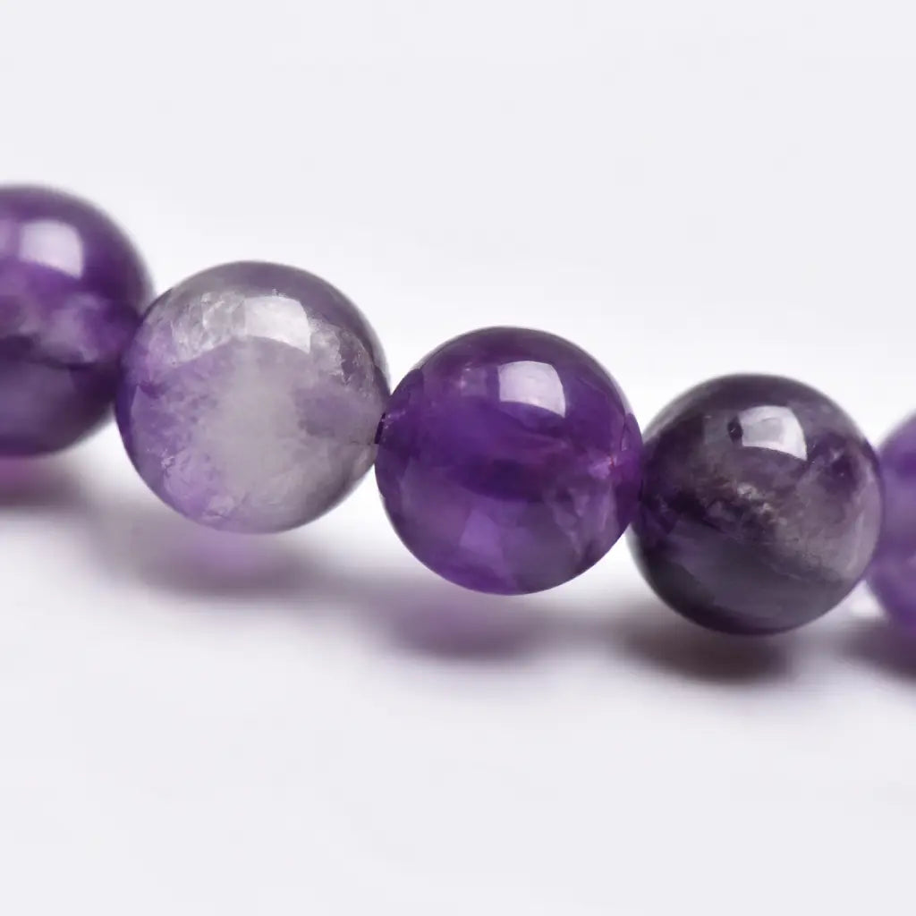 Amethyst jewelry macro crystal bead detail showing polished purple gemstones with luxurious handcrafted bracelet texture