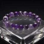 Amethyst jewelry natural crystal bead bracelet on clear display stand featuring calming gemstone energy and luxury appeal