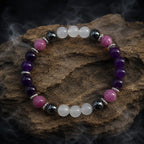 Amethyst crystal bracelet arranged on textured stone with healing gemstone beads for peaceful energy