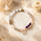 Aquarius stone bracelet with healing gemstones and silver zodiac pendant photographed in luxury crystal setting.