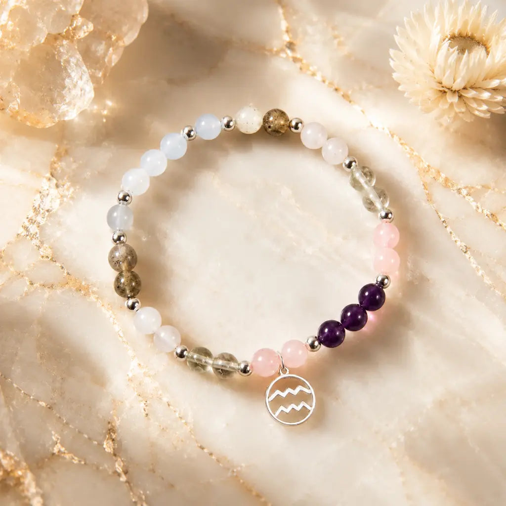 Aquarius stone bracelet with healing gemstones and silver zodiac pendant photographed in luxury crystal setting.