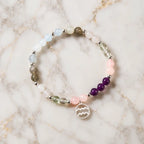 Aquarius stone bracelet featuring amethyst and rose quartz beads displayed on marble for chakra harmony styling.