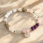 Aquarius stone bracelet styled on marble surface with gemstone beads and silver charm for calming spiritual energy.