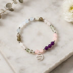 Aquarius stone bracelet on white marble with pastel crystal beads and zodiac charm for elegant astrology fashion.