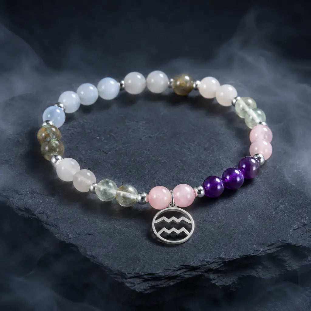 Aquarius stone bracelet styled on textured stone platform with crystal gemstones for luxury astrology inspired fashion.