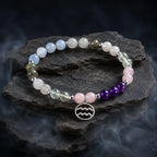 Aquarius stone bracelet displayed on dark marble with crystal beads and silver charm for mystical zodiac energy.