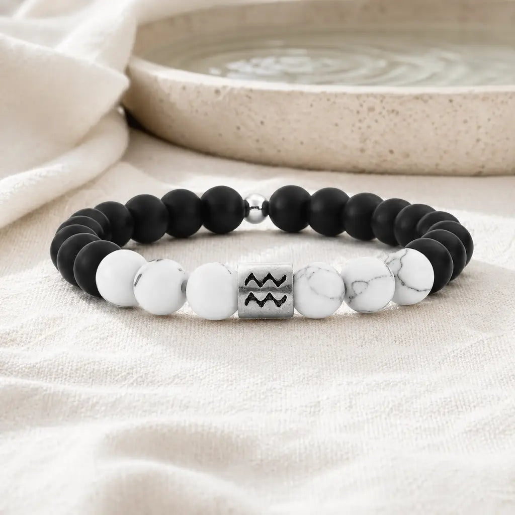 Aquarius zodiac bracelet displayed on soft fabric with onyx and howlite beads for calming everyday balanced energy