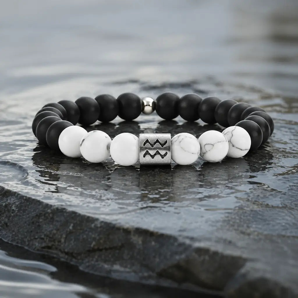 Aquarius zodiac bracelet on dark wet stone with black onyx, white howlite, and silver charm for bold water sign style