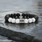 Aquarius zodiac bracelet on dark wet stone with black onyx, white howlite, and silver charm for bold water sign style