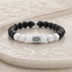 Aquarius zodiac bracelet on beige stone tray with black onyx, white howlite, and silver bead for elevated gifting