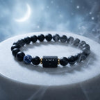 Aries zodiac bracelet on white pedestal with black beads, blue stone accent, and dreamy lunar styling appeal today
