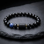 Aries zodiac bracelet on dark slate with glossy black beads, blue gemstone detail, and premium gift appeal today