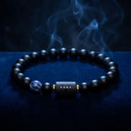 Aries zodiac bracelet on deep blue backdrop with black beads, blue stone detail, and mystical evening style and appeal