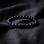 Aries zodiac bracelet on black fabric with matte beads, blue stone detail, and refined celestial styling appeal