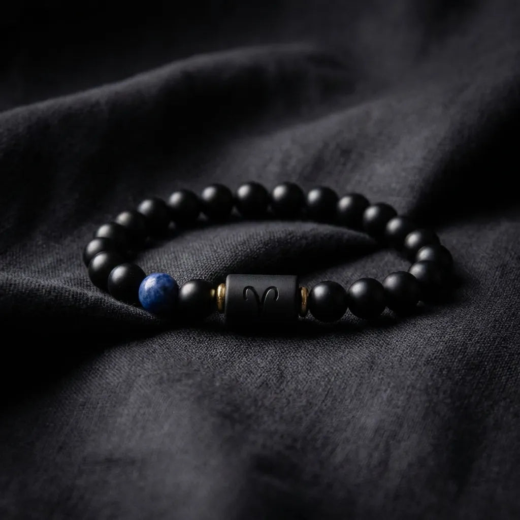 Aries zodiac bracelet on black fabric with matte beads, blue stone detail, and refined celestial styling appeal