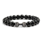 Barbell beaded bracelet in black with gun-black connector, showing 8 mm round beads, a dumbbell-shaped connector, and a circular unisex strand against a clean white studio setting.
