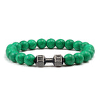 Barbell beaded bracelet in dark green with gun-black connector, showing 8 mm round beads, a dumbbell-shaped connector, and a circular unisex strand on a clean white studio setting.