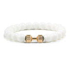 Barbell beaded bracelet in glossy white with gold-color connector, showing 8 mm round beads, a dumbbell-shaped connector, and a circular unisex strand on a bright white background.