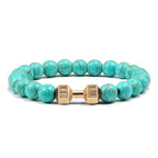 Barbell beaded bracelet in turquoise-color with gold-color connector, showing 8 mm round beads, a dumbbell-shaped connector, and a circular unisex strand on a clean white backdrop.