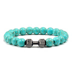 Barbell beaded bracelet in turquoise-color with gun-black connector, showing 8 mm round beads, a dumbbell-shaped connector, and a circular unisex strand on a bright white backdrop.
