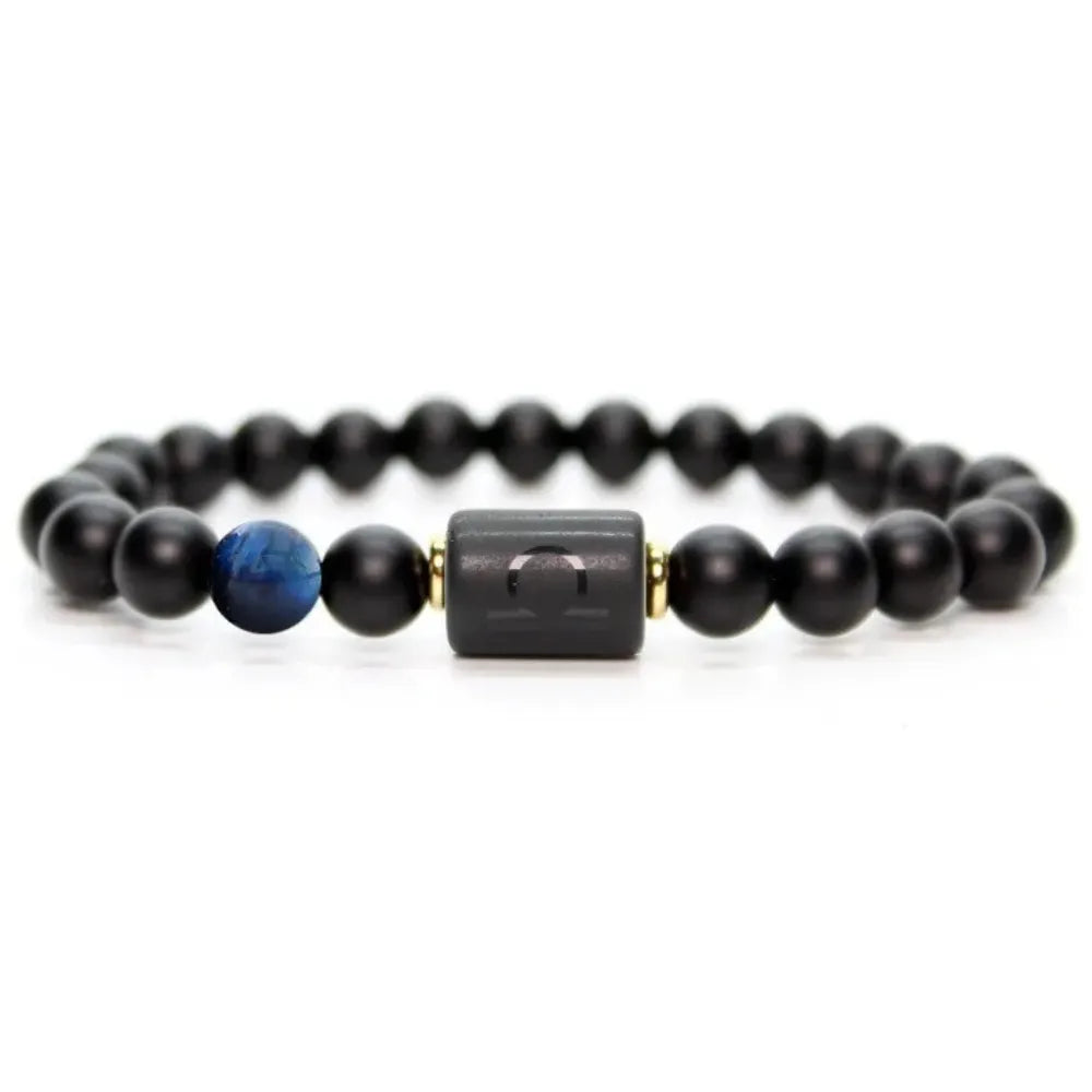 Libra zodiac bracelet with glossy black beads, blue accent stone, and engraved center bead on agate plate with smoke.