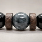 Black Obsidian labradorite bracelet macro showing the natural labradorite centerpiece with wood spacers and polished gemstone craftsmanship.