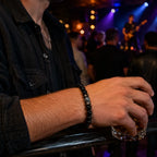 Black Obsidian labradorite bracelet worn at a live music venue featuring polished gemstone beads for modern men's fashion and everyday wear.