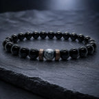 Black Obsidian labradorite gemstone bracelet displayed on a dark slate surface featuring polished natural crystal beads for premium everyday style.