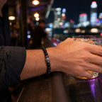Black Obsidian labradorite beaded bracelet worn while holding a drink highlighting natural crystal jewelry for sophisticated evening fashion.