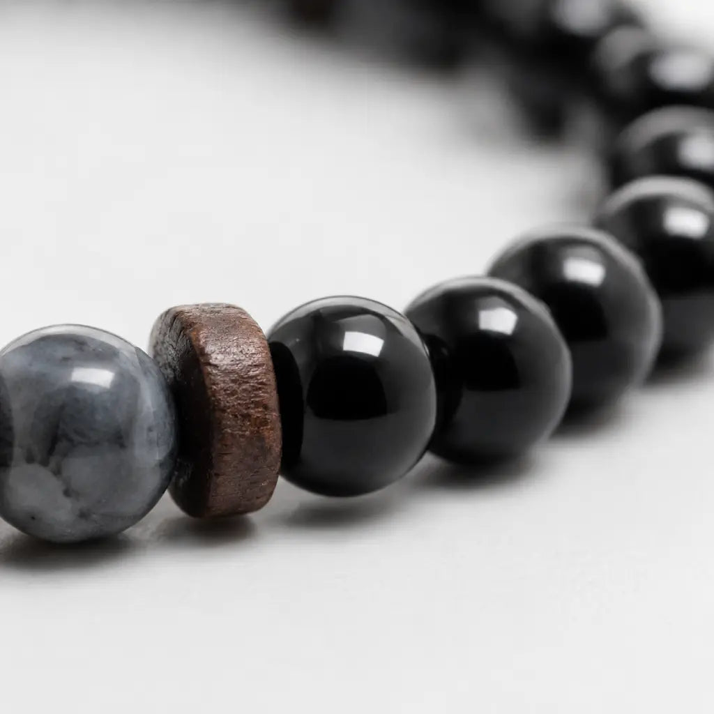 Black Obsidian labradorite bracelet detailed view of polished obsidian beads with natural wood accents highlighting premium stone jewelry.
