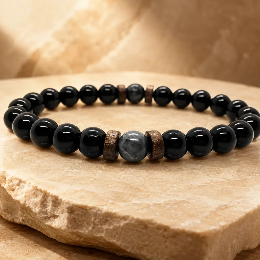 Black Obsidian labradorite crystal bracelet displayed on a warm stone platform featuring polished gemstone beads for elegant daily accessories.